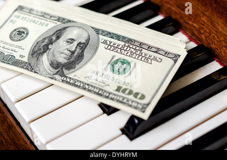Dollars on keyboard of piano. Earn from music. Stock Photo