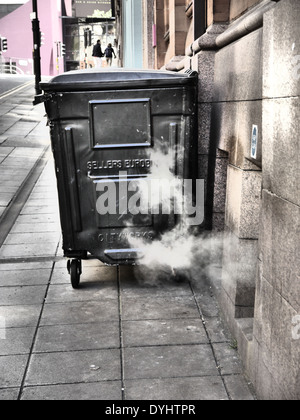 Creative / artistic photographic image of wheelie refuse bin and steam vent in City street, Newcastle upon Tyne, England, UK Stock Photo