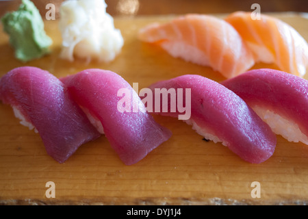 Red maguro (tuna) sushi and sake (salmon) sushi on a wooden chopping board. Stock Photo