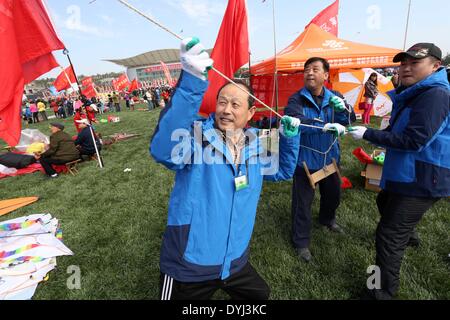 Weifang, China's Shandong Province. 19th Apr, 2014. Participants try to fly a kite during the 31st Weifang International Kite Festival in Weifang, east China's Shandong Province, April 19, 2014. © Zhang Chi/Xinhua/Alamy Live News Stock Photo
