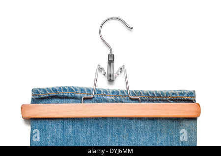 Wooden and metallic trousers hanger with blue jeans, isolated on white background Stock Photo