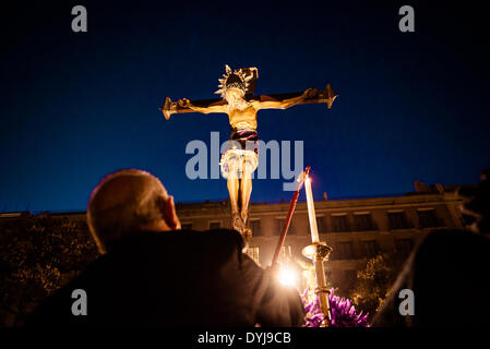 Barcelona, Spain. April 18th, 2014: A worshiper lights a candle on the float of his brotherhood during the Good Friday procession in Barcelona Credit:  matthi/Alamy Live News Stock Photo