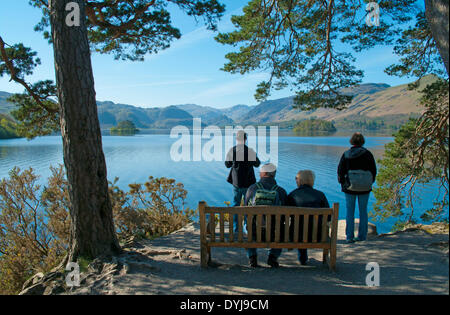 Derwentwater, Keswick, Cumbria, UK. 19th April 2014. Holidaymakers look at the renowned view from Friar's Crag over Derwentwater to Borrowdale, with Cat Bells rising on the right. (A hatch of small flies is lit up as white dots in the sunshine) Credit:  Julie Fryer/Alamy Live News Stock Photo