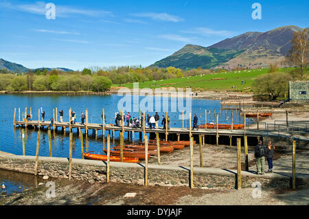 Derwentwater, Keswick, Cumbria, UK. 19th April 2014. Holidaymakers on the jetty await the arrival of the launch for a cruise round Derwentwater, while sheep graze in the nearby meadow, and Skiddaw rises behind Credit:  Julie Fryer/Alamy Live News Stock Photo