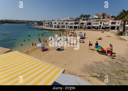 Holiday makers on the beach in the small fishing village of Na Macaret, on the Balearic island of Menorca. Stock Photo