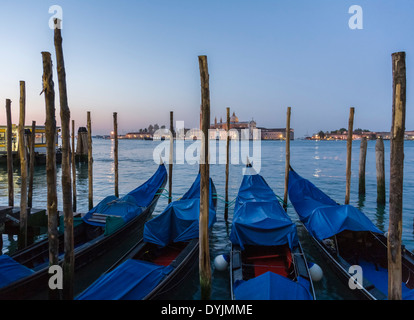 Moored gondolas in the evening on Grand Canal, Venice with San Giorgio Maggiore church and monastery in background Stock Photo