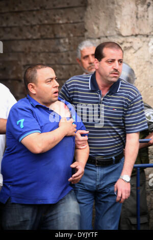 Jerusalem, Jerusalem, Palestinian Territory. 20th Apr, 2014. A Palestinian helps an injured man during clashes with Israeli policemen in Jerusalem's Old City, April 20, 2014. Dozens of Palestinian worshipers were wounded and 25 were detained after clashes broke outside the Al-Aqsa compound when Israeli police denied hundreds of worshippers access to the compound during the visit of Likud member of Knesset Moshe Feiglin © Saeed Qaq/APA Images/ZUMAPRESS.com/Alamy Live News Stock Photo