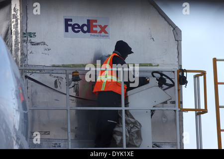 FedEx employee unloading container from the Airbus A300-600 N652FE Federal Express at Ottawa Airport YOW Canada, April 19, 2014 Stock Photo