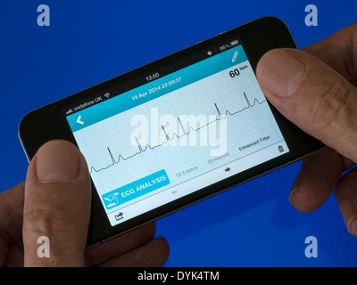 User holding portable ECG EKG Heart Monitor App running on iPhone 4 showing normal sinus heart rhythm with one ectopic heartbeat Stock Photo