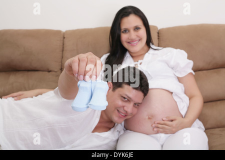 happy couple expecting a baby with socks in hand. Focus in the socks Stock Photo