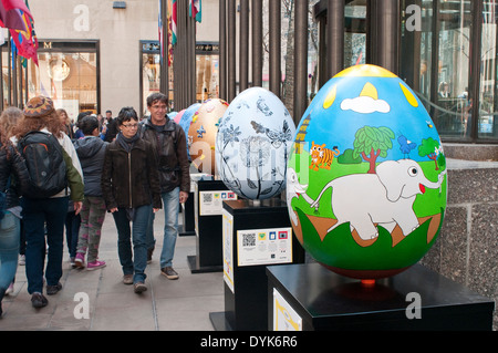 New York, NY - April 20,  2014: Over 260 2-foot eggs are displayed at Rockefeller Center on Easter Sunday as part of the Faberge Big Egg Hunt. The eggs were created by well-known artists and designers and displayed throughout New York City from April 1-17th. On April 18th, the eggs were moved to Rockefeller Center, where they are on display prior to being auctioned. Stock Photo