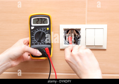 Hand electrician with multimeter checking voltage Stock Photo