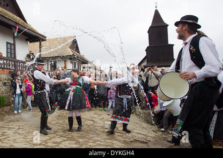 Holloko, Hungary. 21st Apr, 2014. Local men splash water at a girl as part of traditional Easter celebrations in Holloko, a village in northern Hungary, April 21, 2014. Local people from Holloko, which was inscribed on the World Heritage List, celebrate Easter with the traditional 'watering of the girls', a Hungarian tribal fertility ritual rooted in the area's pre-Christian past. Credit:  Attila Volgyi/Xinhua/Alamy Live News Stock Photo