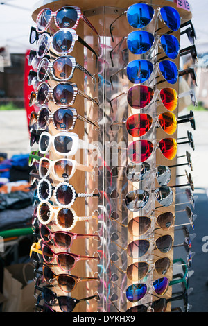 Cheap Sunglasses on a circular spinning display stand for sale. Stock Photo
