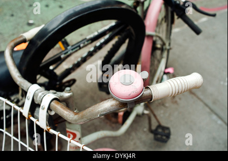 An old pink bicycle with matching pink bell Stock Photo