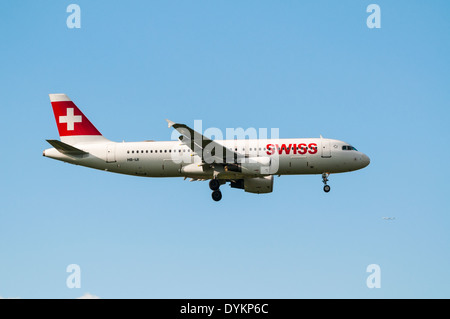 Side view of a Swiss Airbus A320 plane on approach to land with its landing gear down Stock Photo