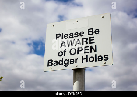 A sign warning about open badger holes Stock Photo
