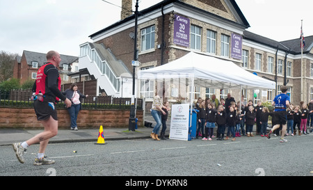 Manchester Marathon 2014 : competitors run past the cheering Altrincham Children's Choir as the run along Market Street Stock Photo