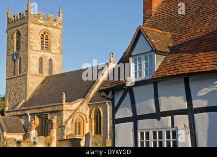 The village church and medieval timber half timbered black and white cottages in the Warwickshire village of Welford on Avon.