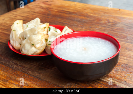 A typical Chinese breakfast of congee and fried pork dumplings Stock Photo