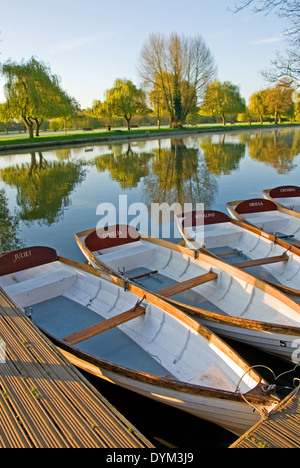 White day hire rowing boats moored to the river bank on the River Avon in the centre of Stratford upon Avon, Warwickshire. Stock Photo