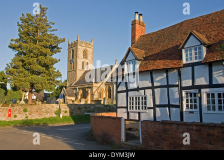 The village church and medieval half timbered black and white cottages in the Warwickshire village of Welford on Avon.