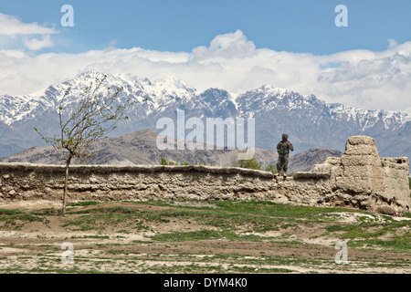 An Afghan military police officer stands on a wall while providing security in a village near Bagram Airfield April 16, 2014 in Parwan province, Afghanistan. Stock Photo