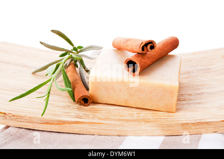 Square cinnamon soap bar with cinnamon isolated on brown towel. Stock Photo