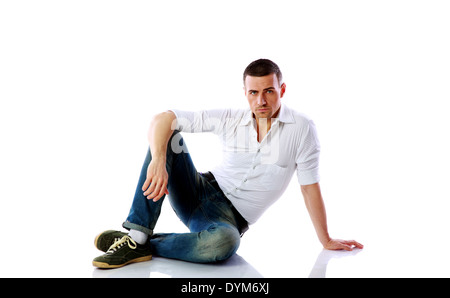 Pensive man sitting at the floor over white background Stock Photo - Alamy