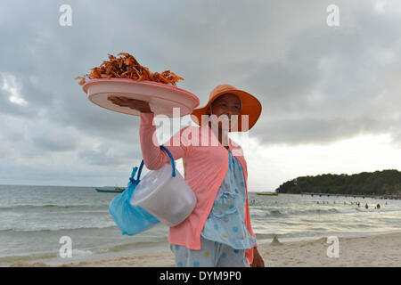 Young Cambodian woman wearing a sun hat selling crabs and shrimps on the beach, Serendipity Beach, Sihanoukville, Preah Sihanuk Stock Photo