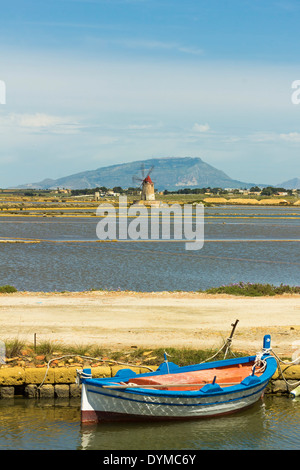 Boat, windmill & Stagnone Lagoon salt pans, with Erice mountain above Trapani beyond; Marsala, Trapani Province, Sicily, Italy Stock Photo