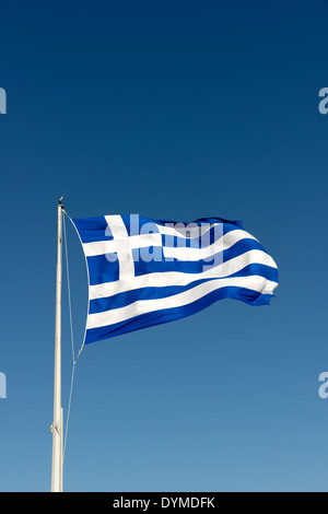 National flag Greece flying high proudly on flag pole against blue sky backdrop Greek flag made up two Stock Photo