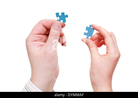 pair of male and female hands with blue puzzle pieces isolated on white background Stock Photo