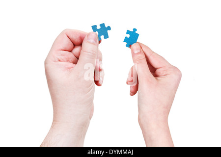 male and female hands holding little puzzle pieces isolated on white background Stock Photo