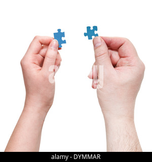 male and female hands holding blue puzzle pieces isolated on white background Stock Photo