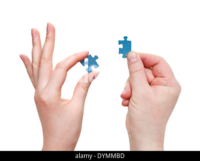 male and female hands connecting blue puzzle pieces isolated on white background Stock Photo