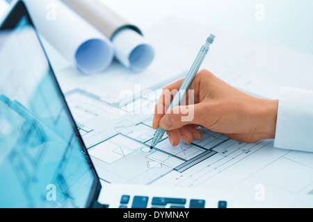 Woman Architect drawing on blueprint construction project Stock Photo