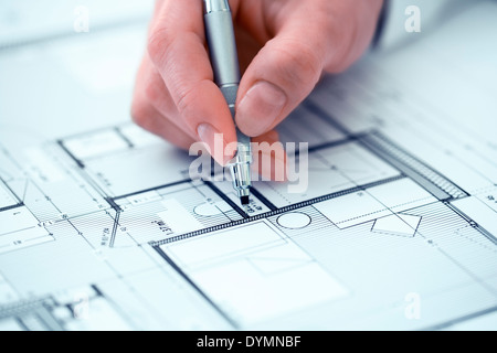 Woman Architect drawing on blueprint construction project Stock Photo
