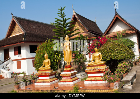 Horizontal view of three Buddha statues at Wat Mai Suwannaphumaham or New Monastery in Luang Prabang on a sunny day Stock Photo