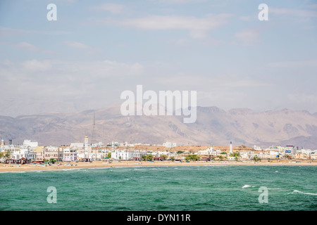 Image of a view to Sur in Oman with sea, mountains, houses and sky Stock Photo