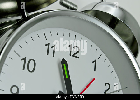Close up of a Clockface on a traditional chrome silver Alarm clock with bells on the top