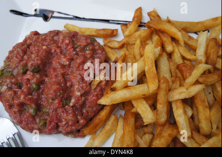 plate of steak tartare with french fries on a white plate at a French restaurant Stock Photo