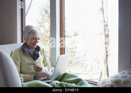 Senior woman shopping online on sofa Stock Photo