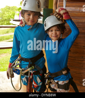 Mixed race boys preparing to zip line Stock Photo