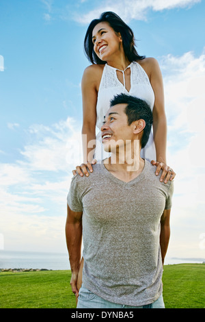 Man carrying girlfriend in rural landscape Stock Photo