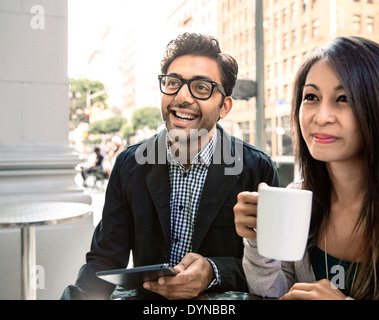 Couple enjoying coffee at sidewalk cafe Stock Photo