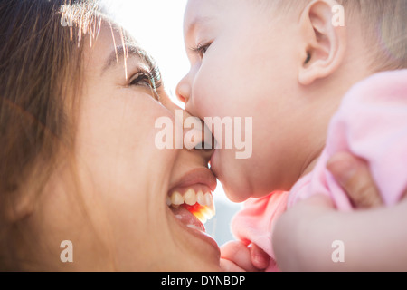 Mother playing with baby girl outdoors