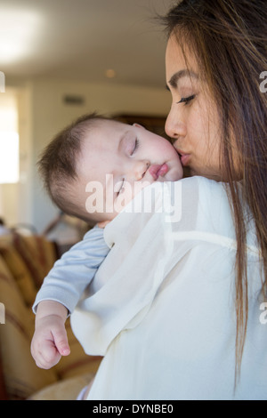 Mother kissing sleeping baby girl Stock Photo