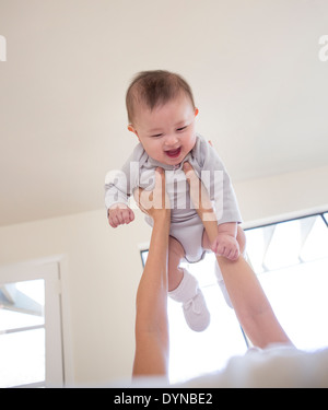 Mother holding baby girl overhead Stock Photo