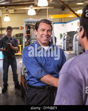 Manager and worker shaking hands in warehouse Stock Photo